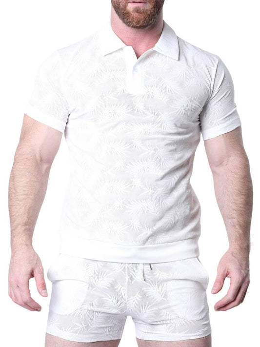 Man wearing a white patterned shirt against a perforated metal background