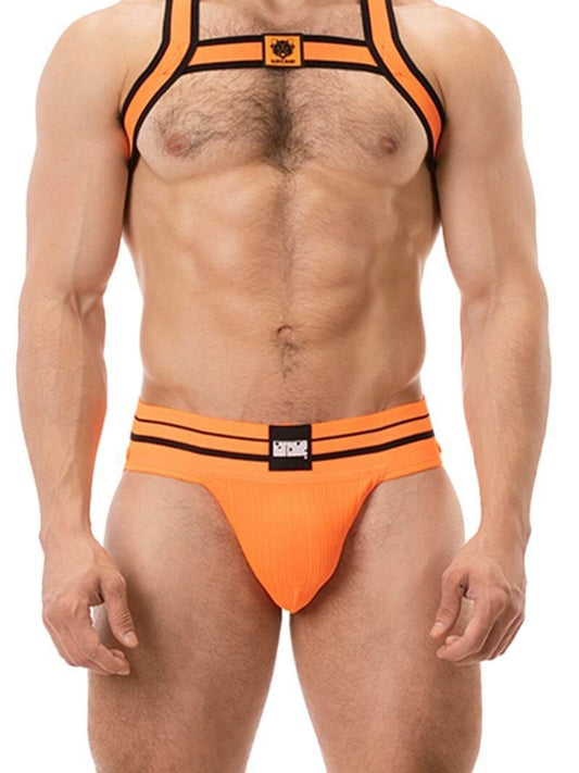 A model wearing a pink BARCODE Berlin Andreus jockstrap, with the brand label visible on the striped waistband, showcasing the product's design and fit.