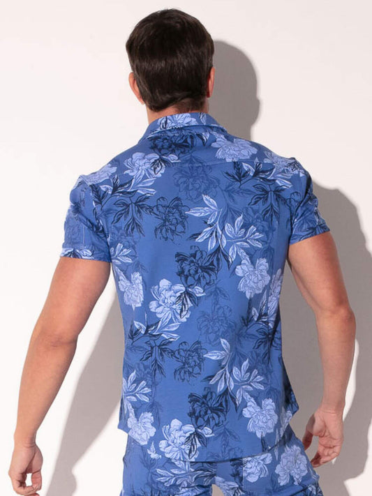 Person wearing a blue floral patterned shirt against a white background