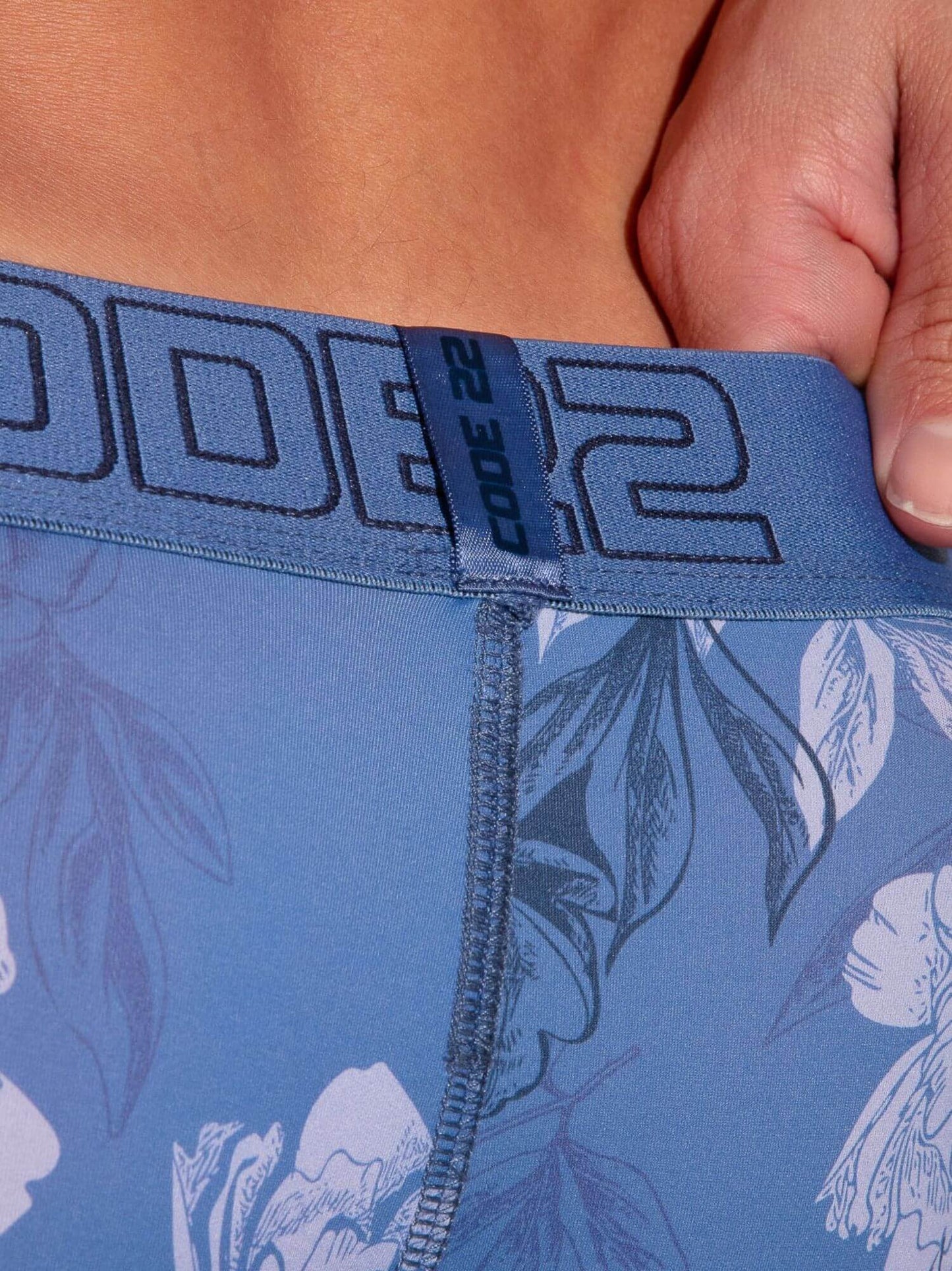 Close-up of a blue floral boxers with a brand logo on the waistband.