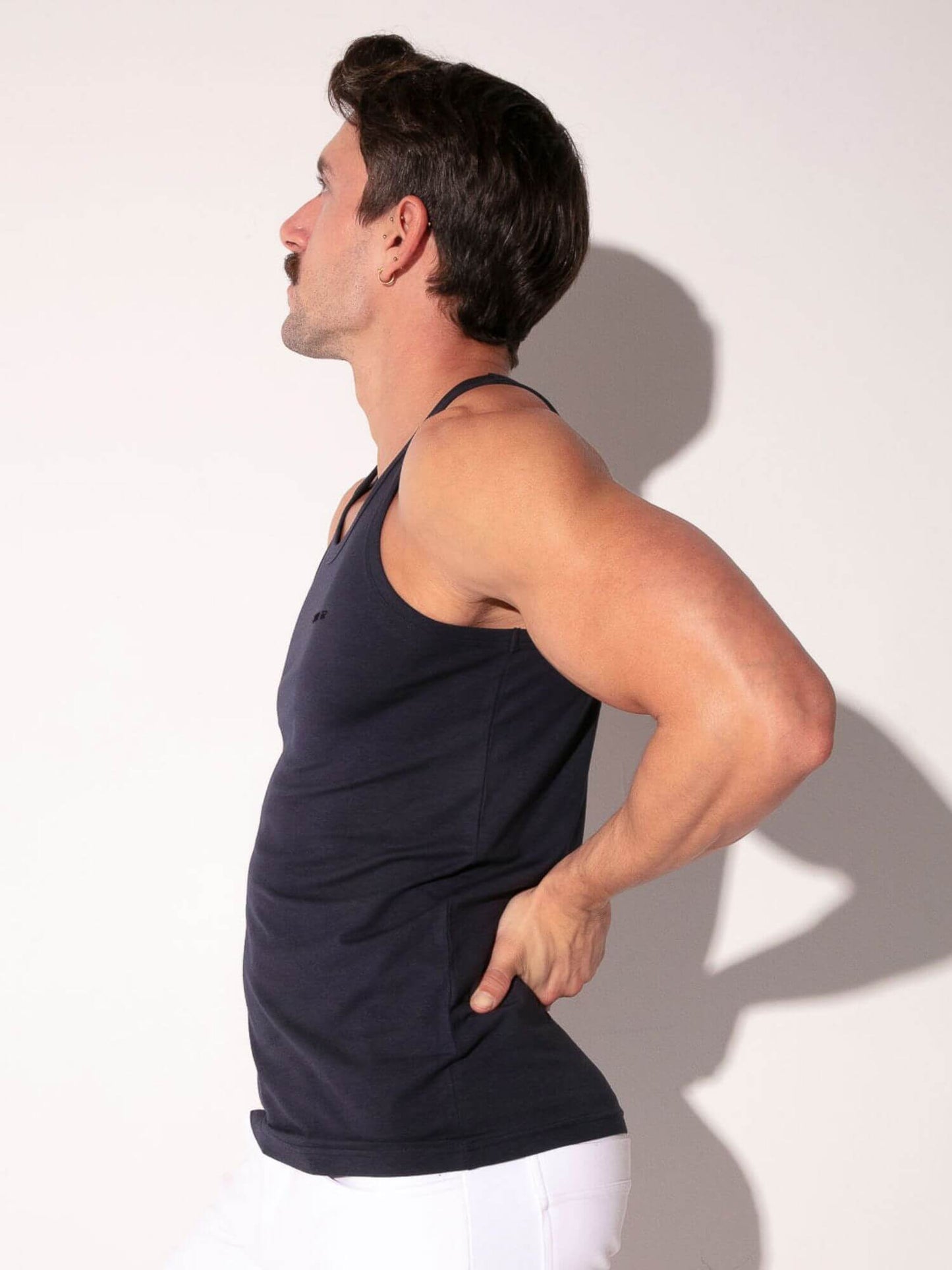 Man wearing a black tank top against a white background