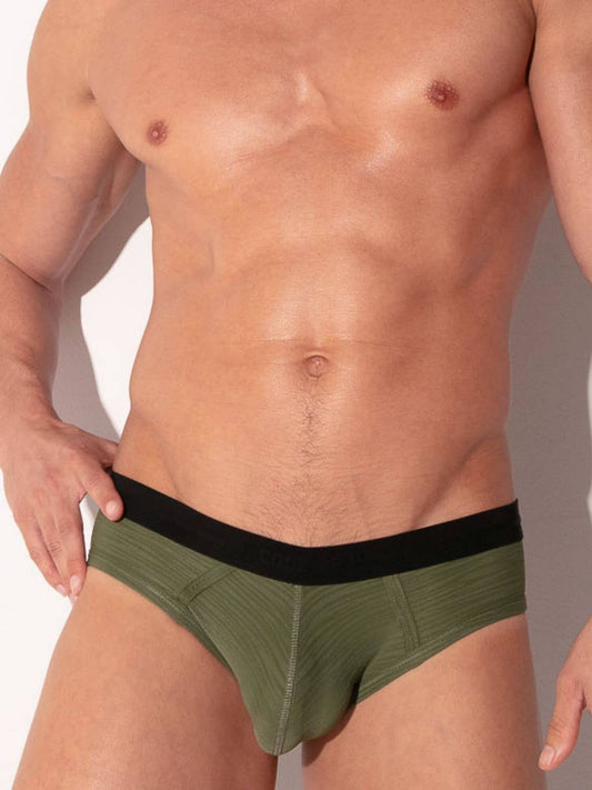 Man wearing a green and black men's underwear set on a neutral background