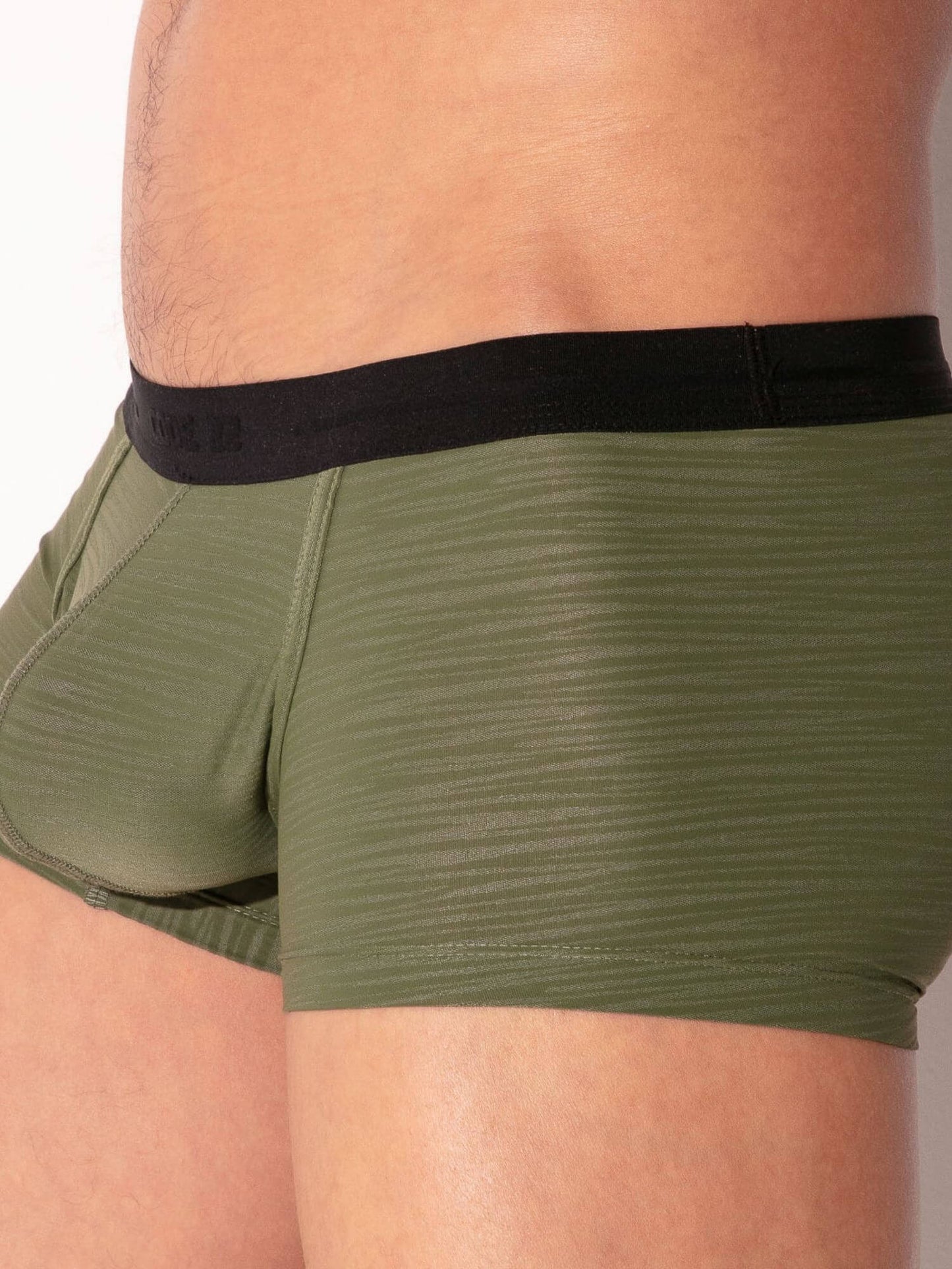 Green boxer briefs with black waistband on a neutral background
