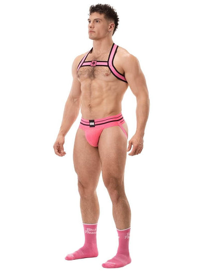 A model wearing a pink BARCODE Berlin Andreus jockstrap, with the brand label visible on the striped waistband, showcasing the product's design and fit.