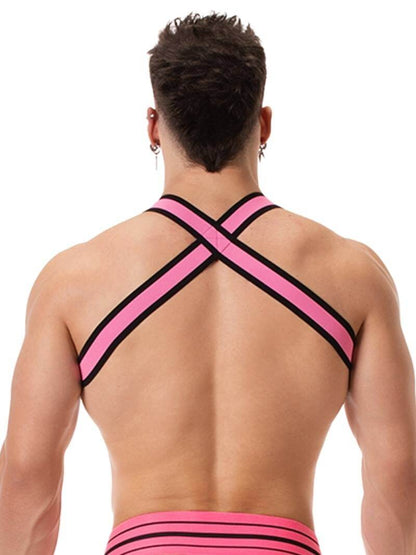 A male model wearing a neon pink and black elastic chest harness with the BARCODE Berlin brand emblem on the front horizontal strap.