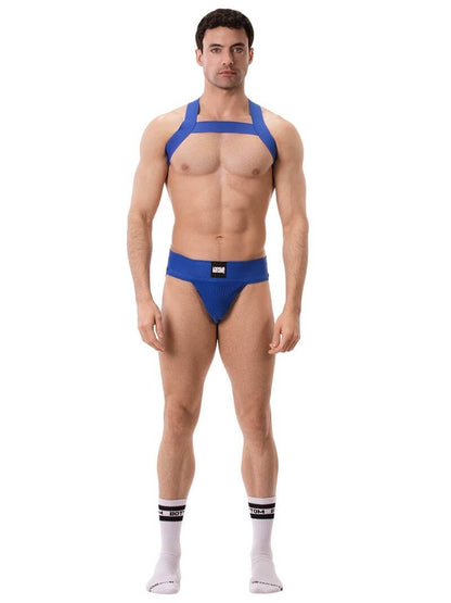 A man wearing a blue elastic chest harness with straps across the chest and over the shoulders.