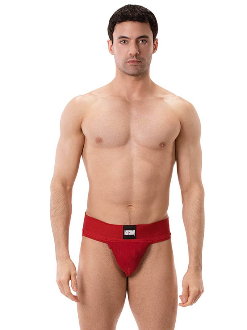 A model wearing a white Barcode Berlin Sergey ribbed cotton jockstrap, with the brand label visible on the waistband.