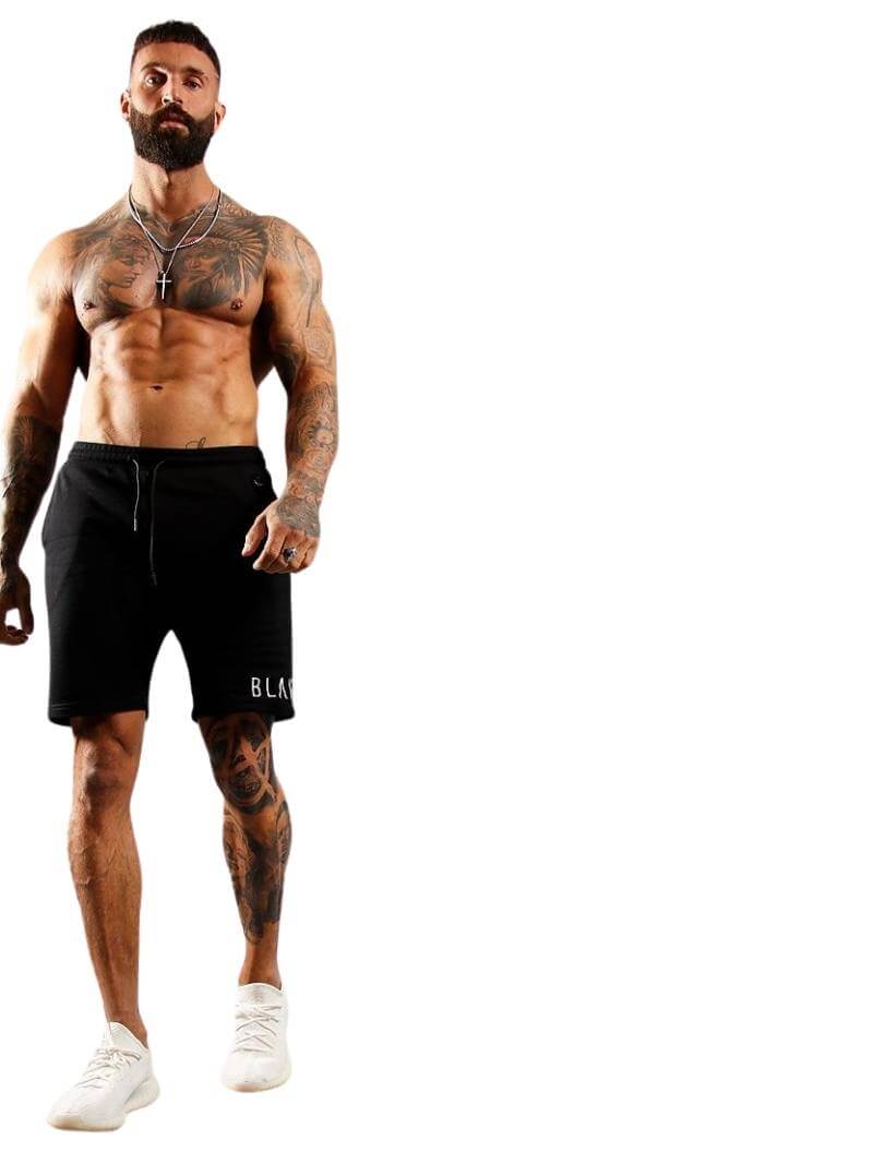 Muscular man wearing black shorts with a brand logo on a white background