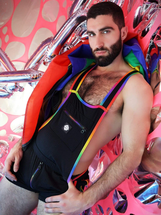 Man wearing a colorful rainbow body suit sitting on a vibrant, abstract background