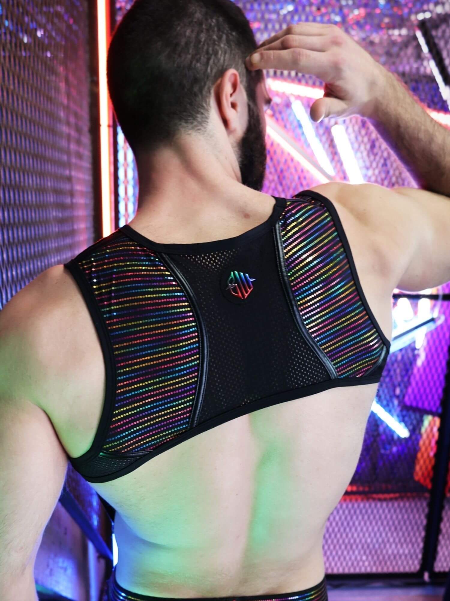 Person wearing a colorful harness with a vibrant, multicolored background.