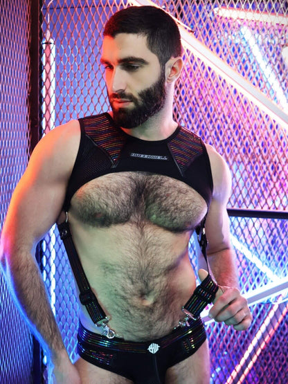Man wearing a black harness with a metallic sheen against a colorful background