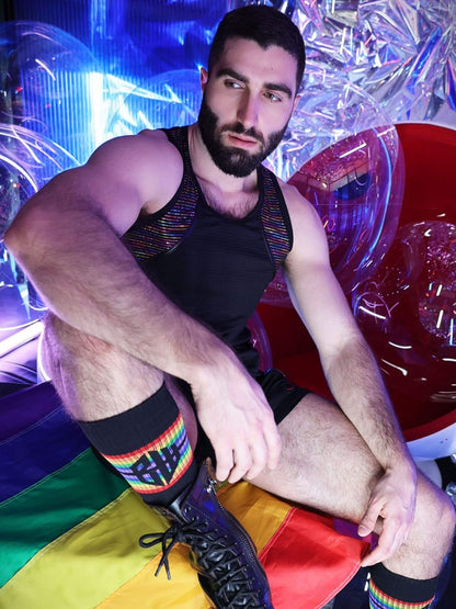 Man sitting on a colorful chair with rainbow socks in a vibrant setting