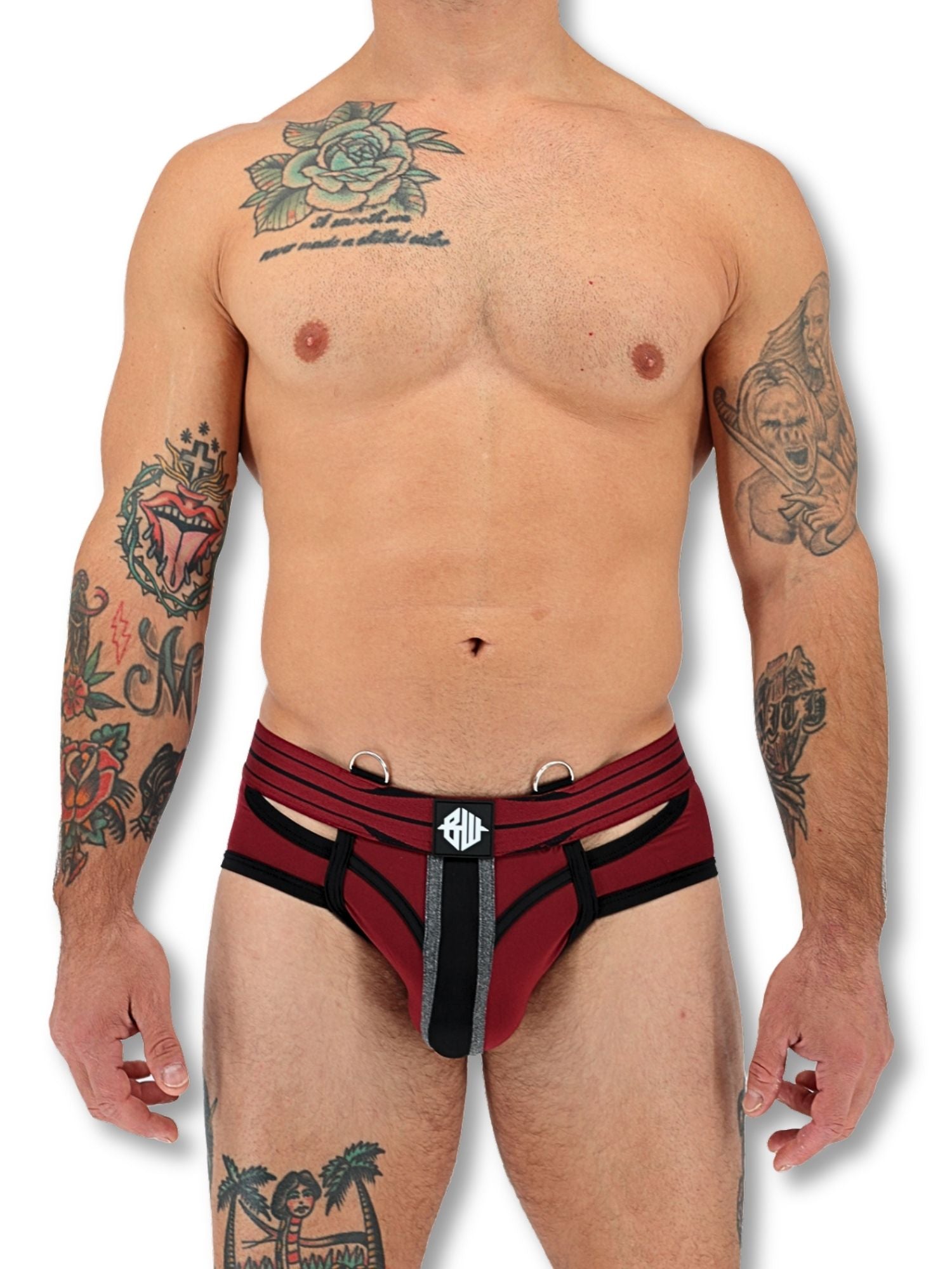 Man wearing a red and black underwear with visible tattoos on a white background