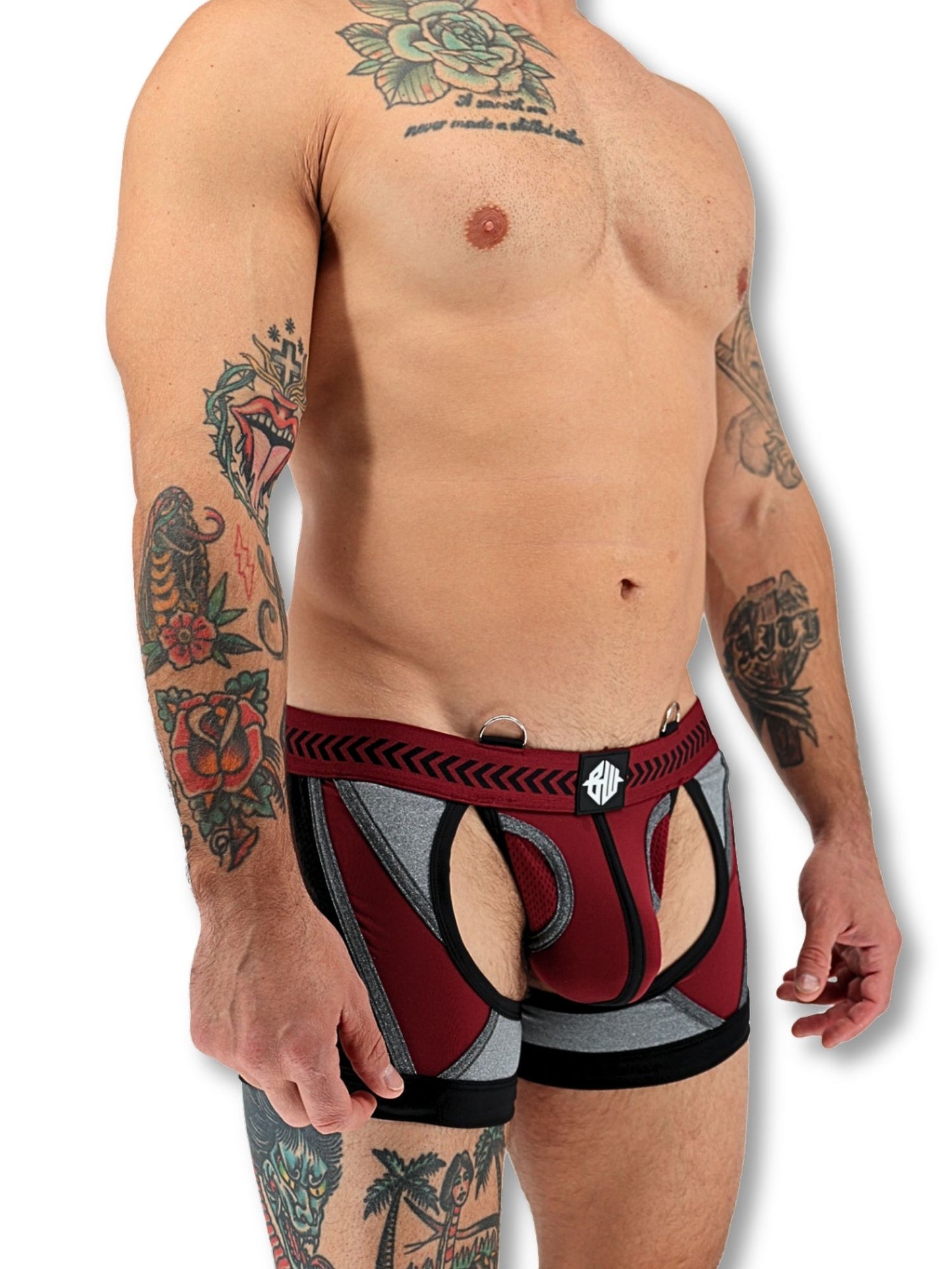 Man wearing a red and grey athletic outfit with tattoos on arms and chest.