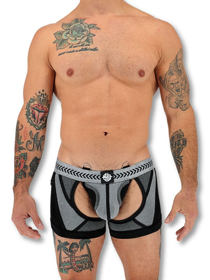 Man wearing black and grey boxer briefs with tattoos on arms and back.