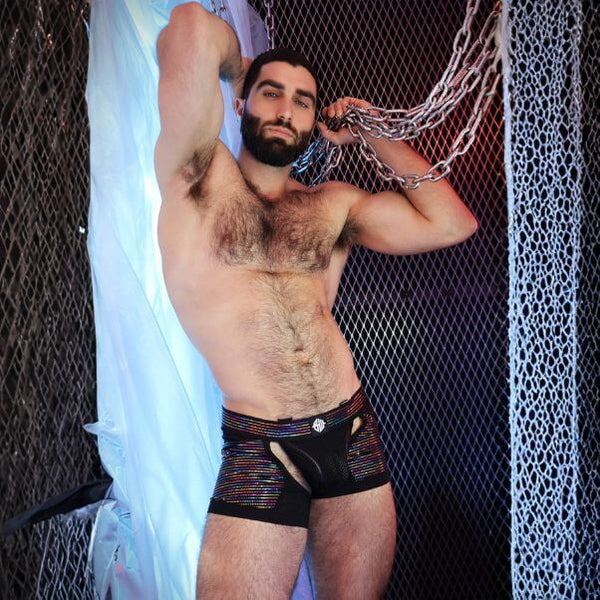 Man wearing black underwear with colorful accents against a dark background