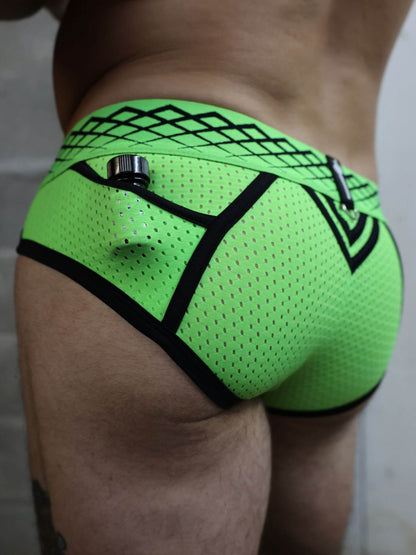 Neon green men's underwear with black mesh and patterns on a neutral background