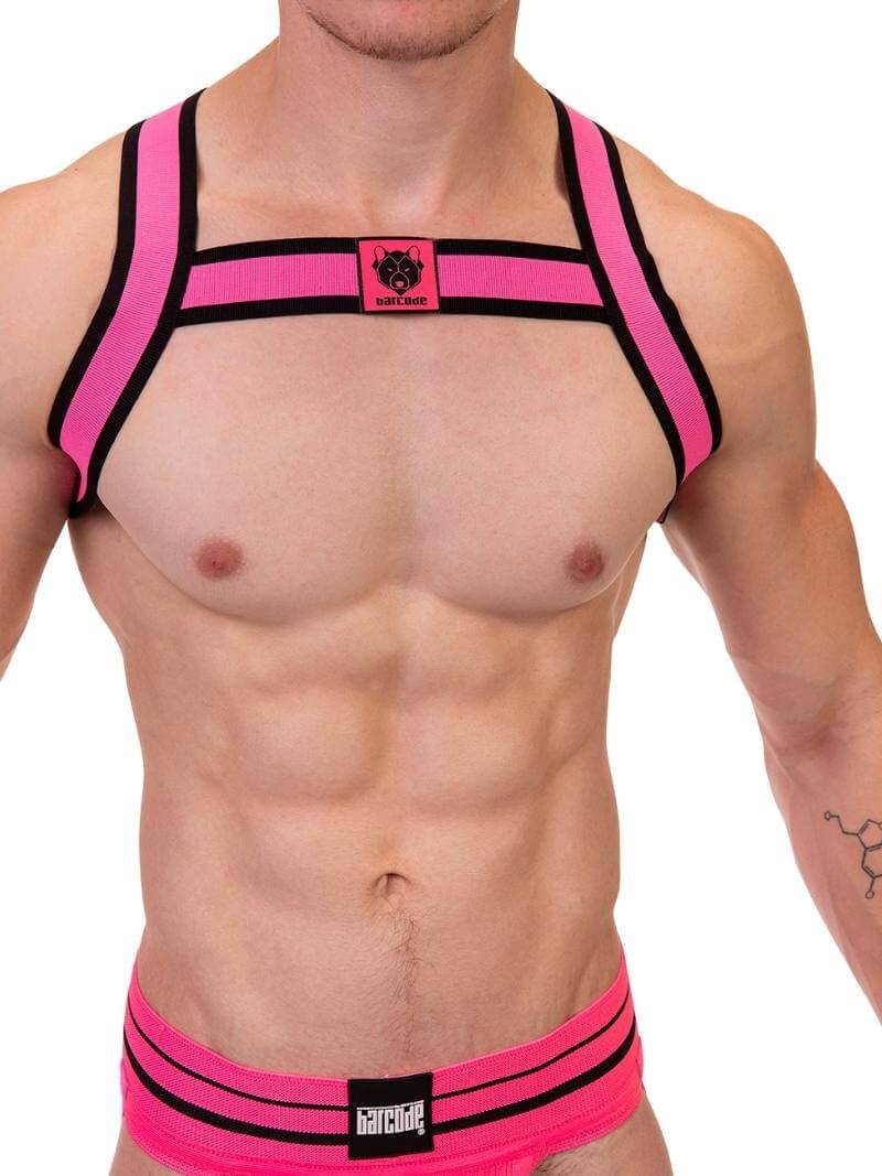 A male model wearing a neon pink and black elastic chest harness with the BARCODE Berlin brand emblem on the front horizontal strap.