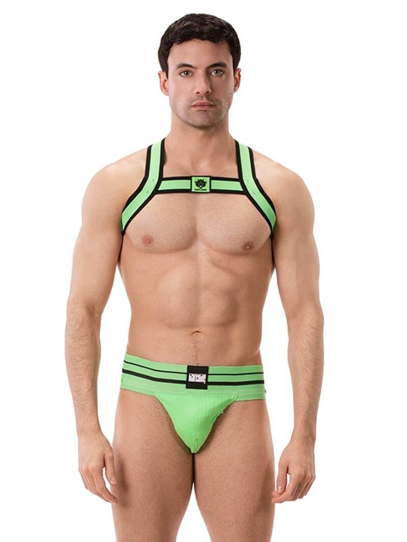 A model wearing a neon green and black elastic chest harness with the BARCODE Berlin brand emblem on the front horizontal strap.