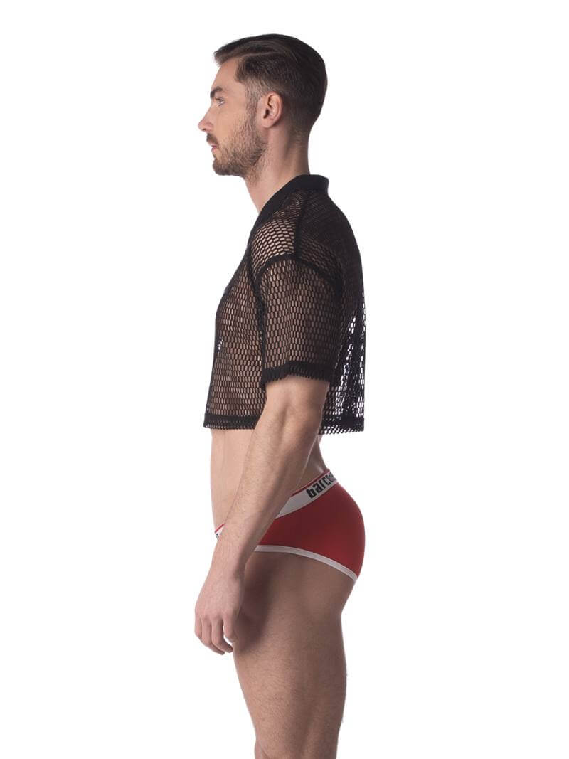 A male model wearing a black semi-see-through mesh fishnet crop top with short sleeves and a v-neck, branded with 'BARCODE'.