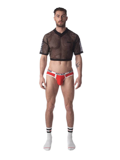 A male model wearing a black semi-see-through mesh fishnet crop top with short sleeves and a v-neck, branded with 'BARCODE'.