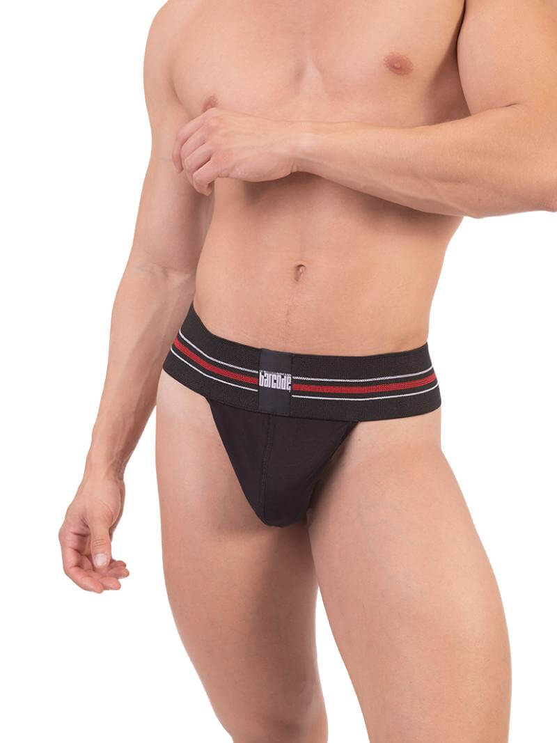 A model wearing a white Barcode Berlin thong, with the brand label visible on the waistband.