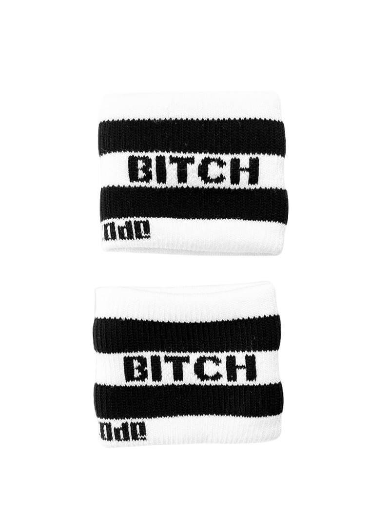 A hand holding two white wristbands with gay pride stripes