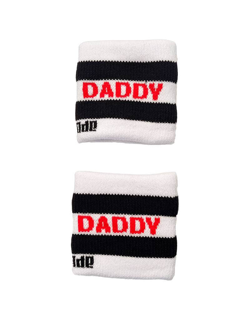 A hand holding two white wristbands with gay pride stripes