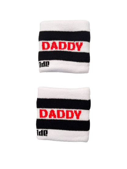 A hand holding two white wristbands with gay pride stripes
