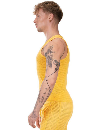 Person wearing a yellow sleeveless top and pants on a white background