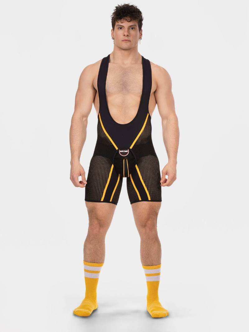 Man wearing a black and yellow wrestling singlet on a white background