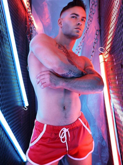 Man wearing red shorts with a neon light background