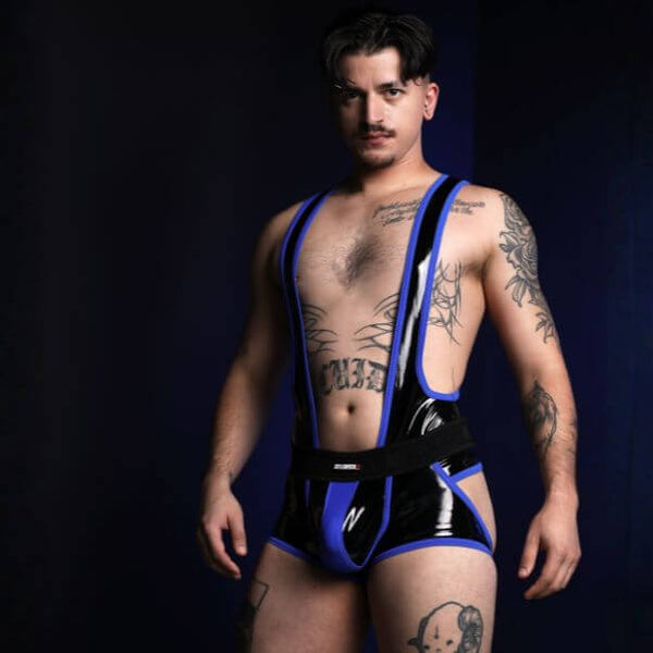 Man wearing a black and blue harness against a dark background