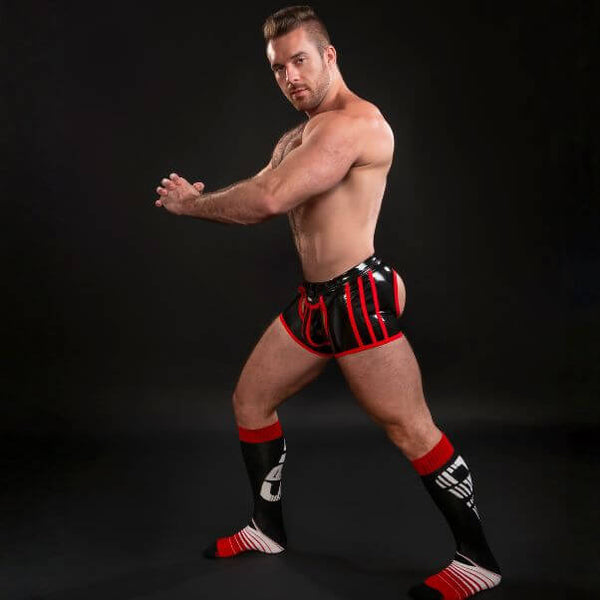 Man in black and red latex underwear on a black background