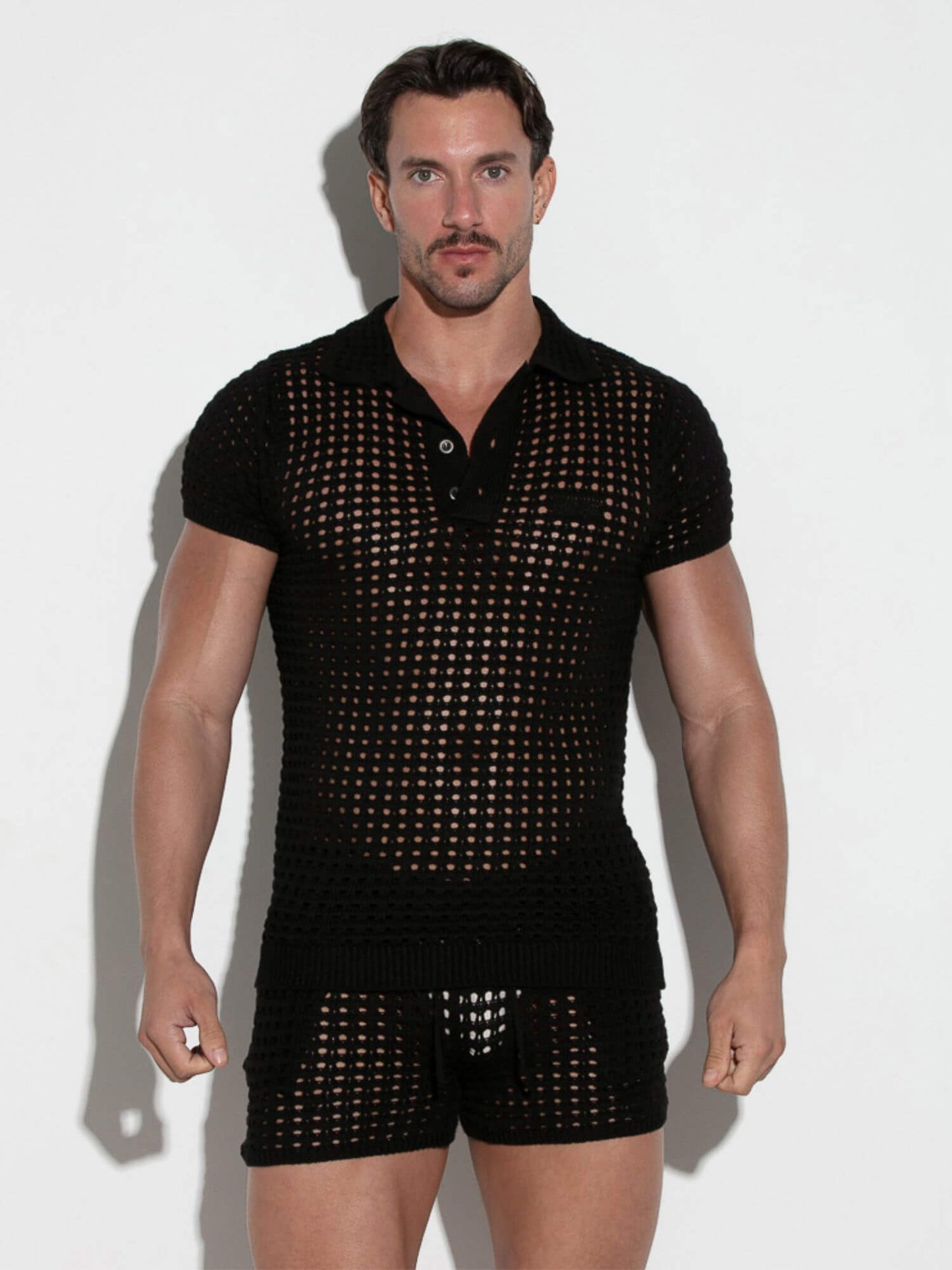 Man wearing a black mesh outfit on a white background