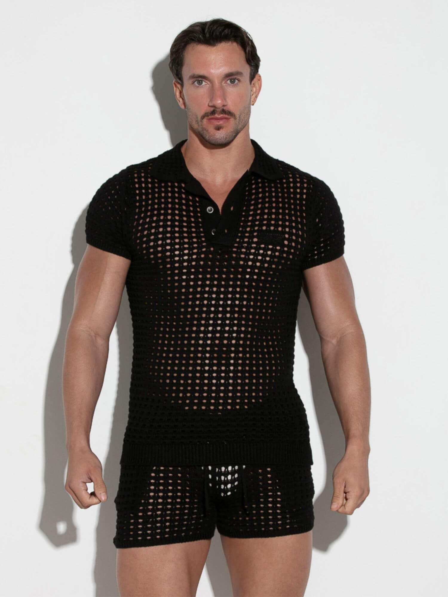 Man wearing a black mesh outfit on a white background