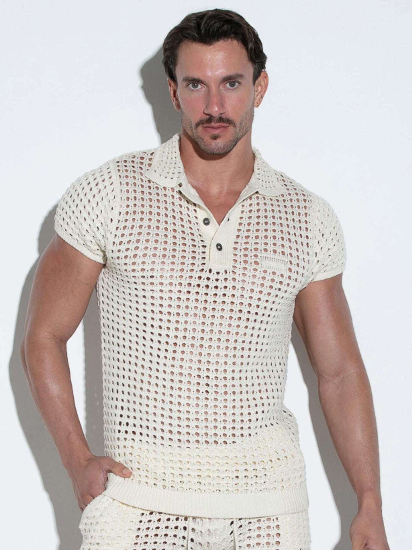 Man wearing a textured white outfit against a plain background