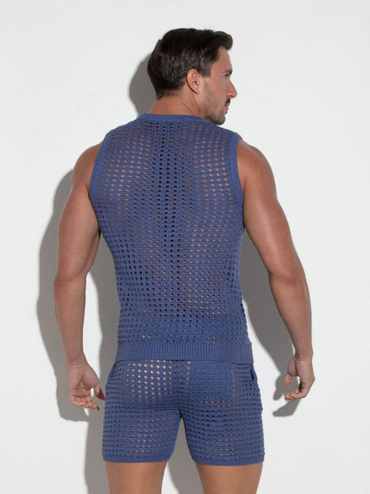 Man wearing a blue crochet sleeveless top and shorts against a white background