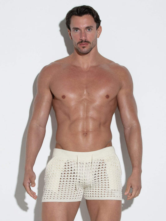Man wearing white shorts against a plain background