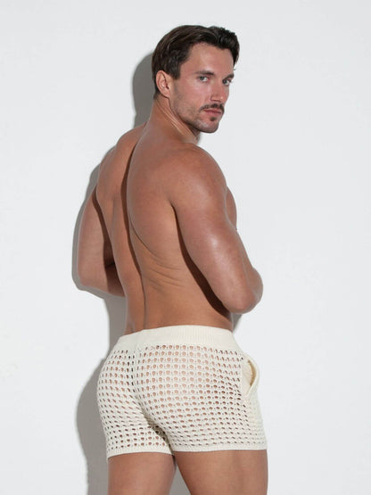Man wearing beige shorts against a white background