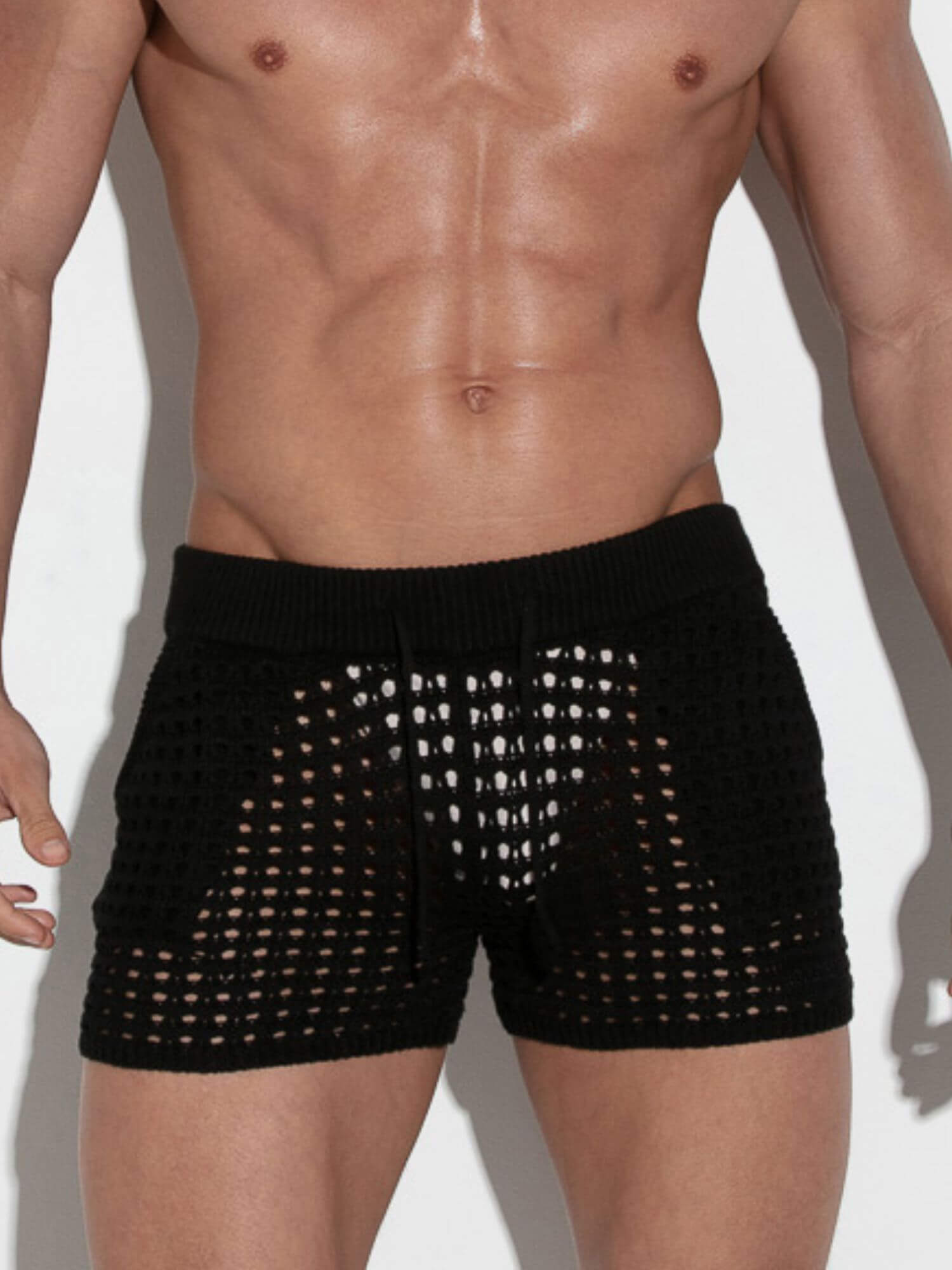 Black mesh shorts worn by a person on a white background