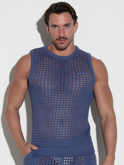 Man wearing a blue sleeveless knit outfit against a white background