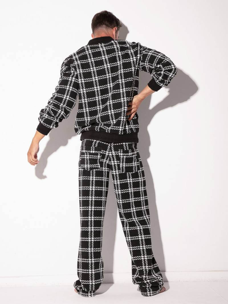 Person wearing a black and white plaid outfit on a white background