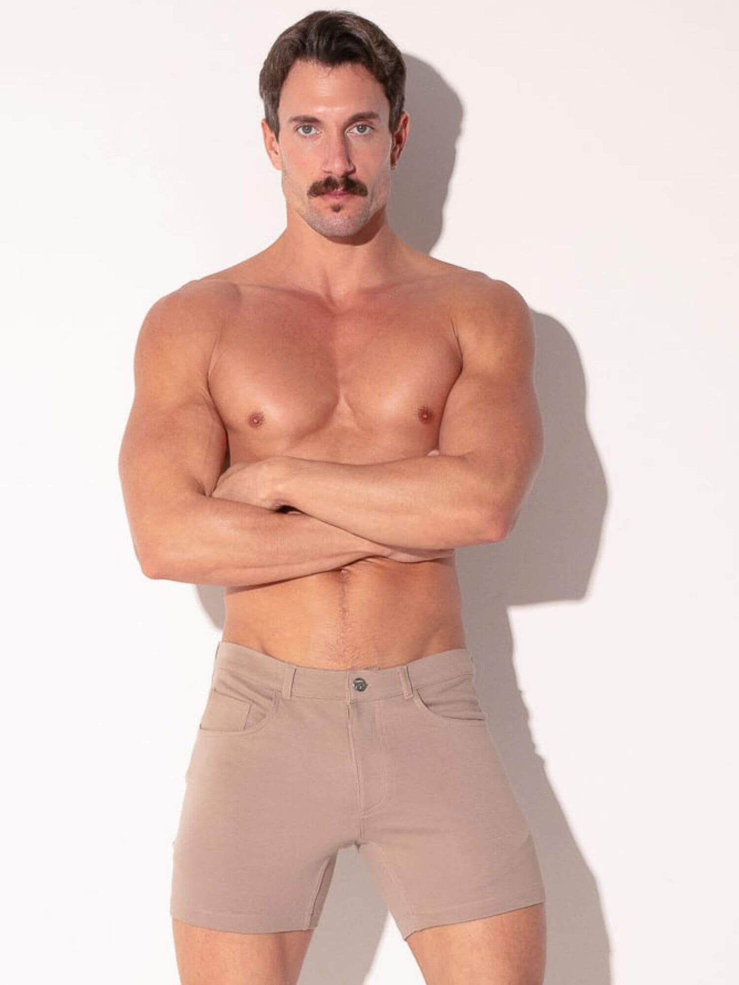 Man wearing beige shorts against a white background