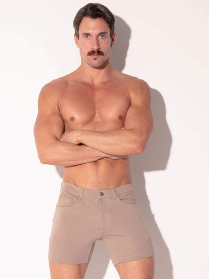 Man wearing beige shorts against a white background