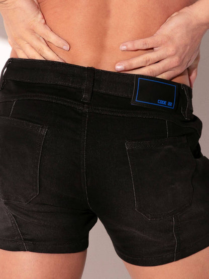 Black shorts with a brand label on a neutral background