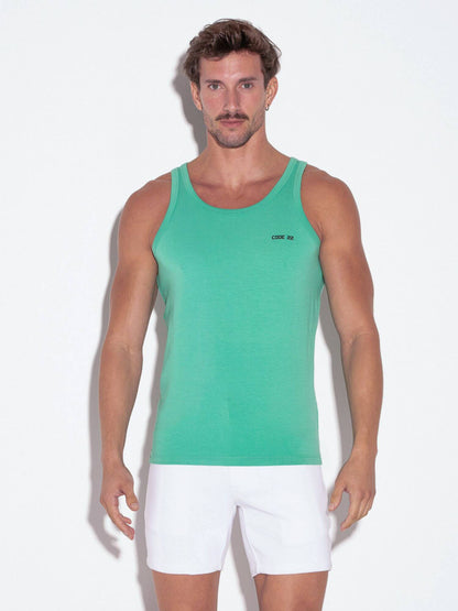 Man wearing a green tank top and white shorts on a white background