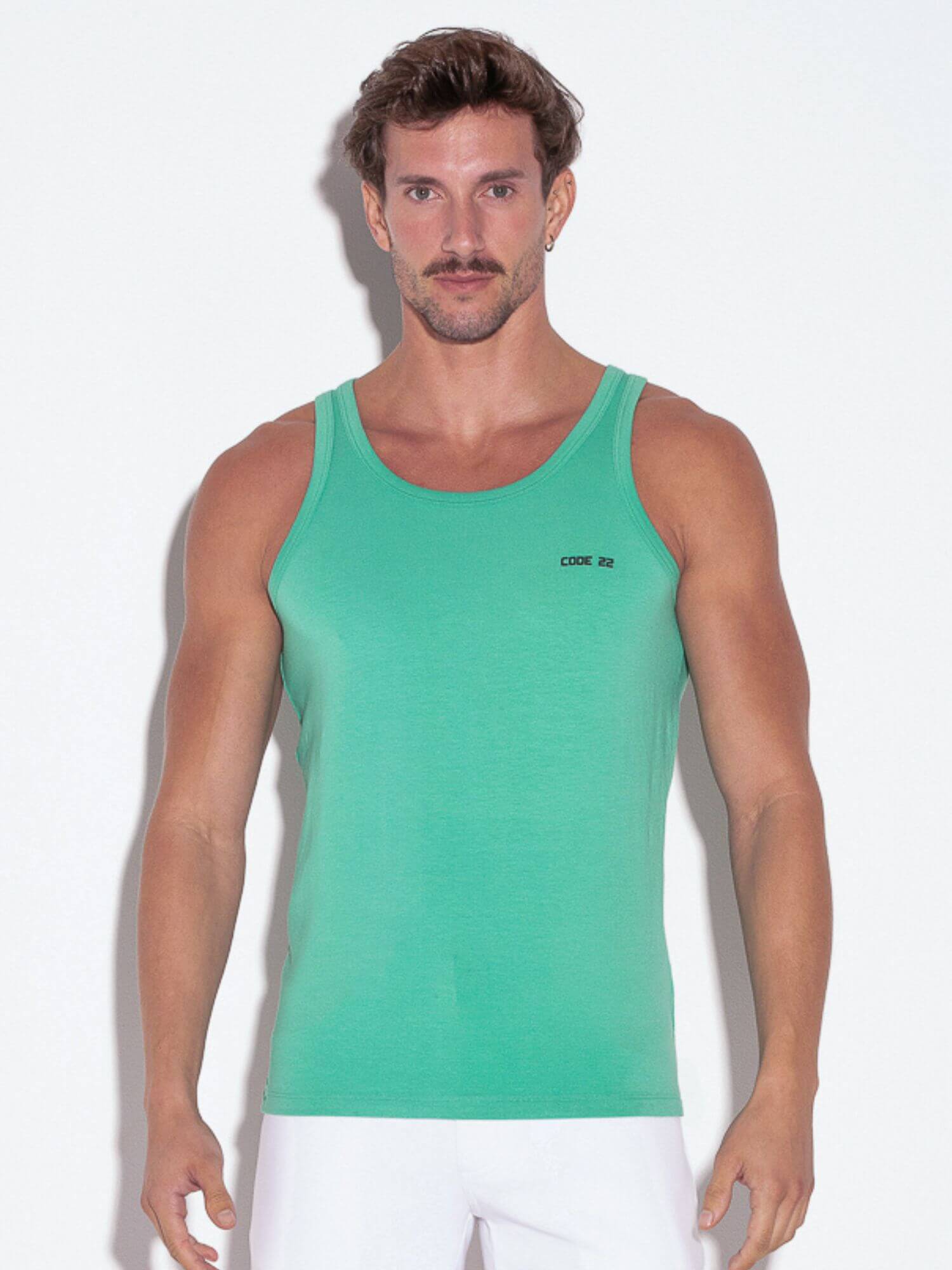 Man wearing a green tank top with a brand logo on a white background