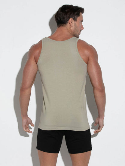 Man wearing a beige tank top and black shorts against a white background