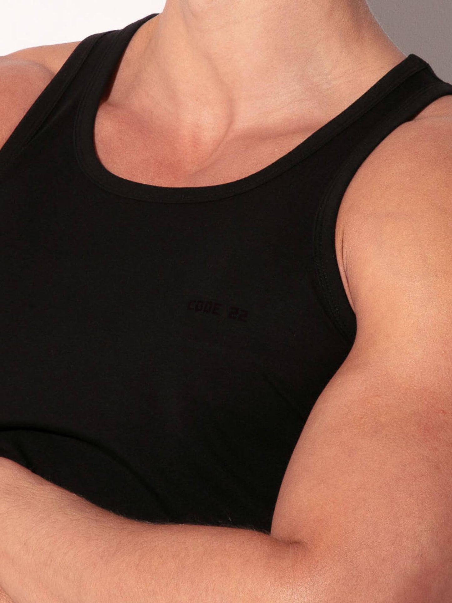 Black tank top worn by a person with a neutral background